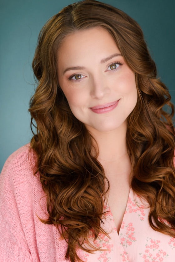Headshot of Katelynn smiling softly in a pink cardigan over a floral top