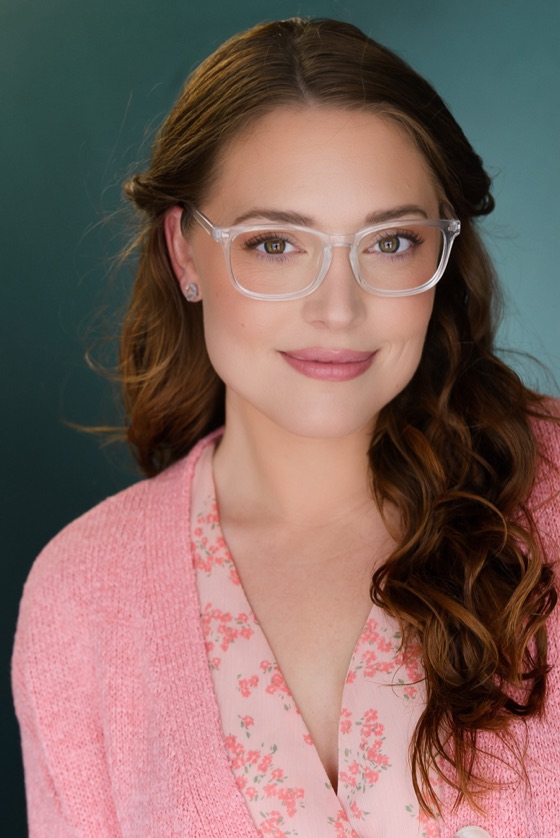 Headshot of Katelynn wearing clear glasses and a pink cardigan